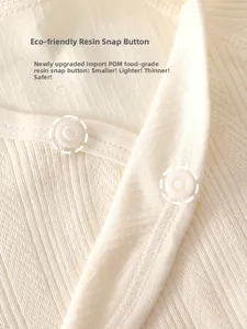 Detail of eco-friendly resin snap buttons on a soft ribbed knit newborn bodysuit