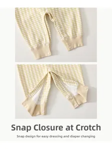 Detail view of baby bodysuit showing resin snap buttons on yellow gingham crotch opening