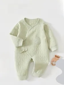 Detail of light green quilted baby romper with embossed star moon texture and tie-up design