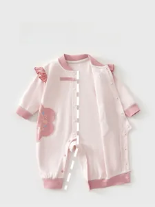 Detail of pink cotton baby romper with floral embroidery and ruffle shoulder trim