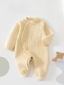 Close-up of quilted star pattern and crescent moon embroidery on infant warm romper