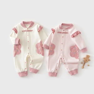 Detail of newborn cotton rompers with traditional Chinese frog buttons and floral embroidery