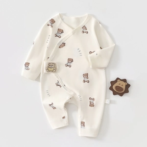 Detail of baby organic cotton romper featuring cute bear print and soft side label