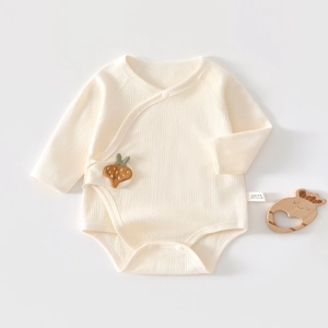 Detail of soft ribbed cotton baby bodysuit with cute strawberry patch and snap buttons