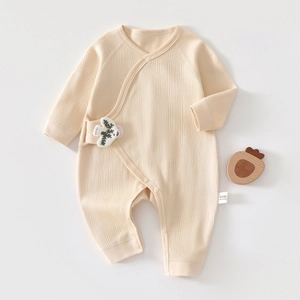 Detail of newborn 100% cotton romper showing ribbed texture and tree embroidery