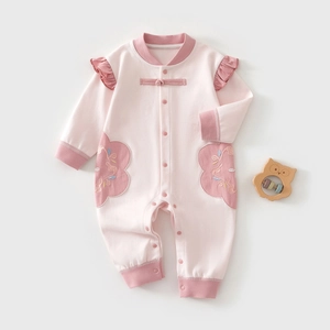 Detailed close-up of pink cotton baby romper featuring traditional Chinese knot buttons