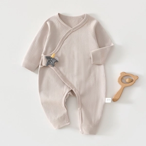 Detail of ribbed organic cotton baby onesie featuring a cute star patch and snap buttons