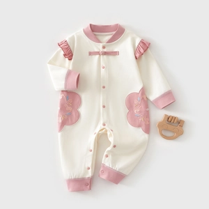 Detail of newborn baby girl cotton romper with Chinese frog buttons and pink flower embroidery