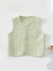 Detailed close-up of light green quilted baby vest with star patterns and moon patch