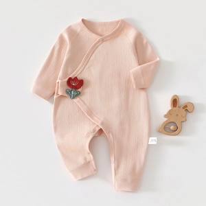 Pink rib-knit cotton newborn romper featuring side-snap closure and floral applique