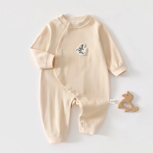 Dettaglio tutina per neonati in cotone a coste con bottoni a pressione e ricami