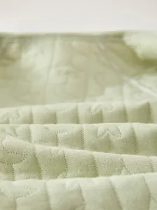Detail of soft quilted baby fabric with embossed star and moon patterns for warmth