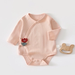 Detail showing the 100% cotton ribbed texture and tulip patch on the pink baby bodysuit