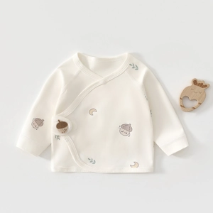 Close-up of soft organic cotton newborn baby shirt with cute hand-drawn forest prints