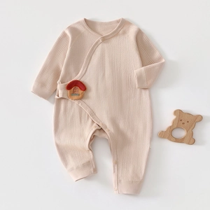 Close-up of pink cotton newborn ribbed bodysuit with cute red mushroom detail