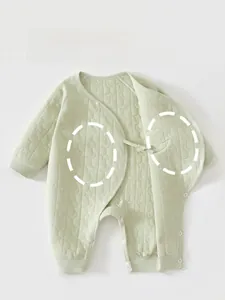 Close-up of quilted moon and stars pattern on green padded cotton baby romper
