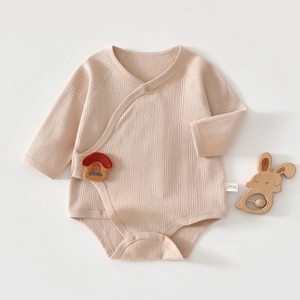 Close-up of baby cotton bodysuit featuring mushroom embroidery and ribbed texture