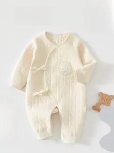 Detail of newborn quilted cotton romper showing crescent moon embroidery and star texture