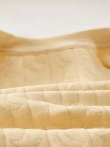 Detailed macro view of soft cotton fabric featuring embossed star and moon patterns