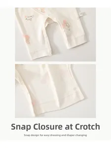 Detail of metal snap buttons on crotch of a cotton newborn baby romper with bear print