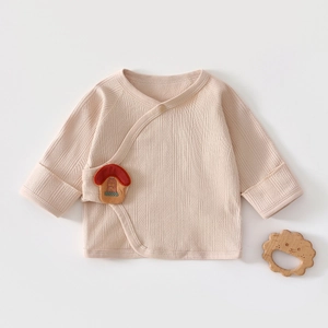 Détail du haut cache-cœur pour bébé en coton bio avec écusson champignon et maille côtelée