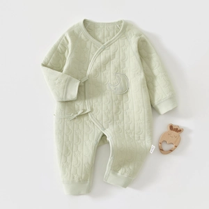 Détail de barboteuse matelassée bébé avec broderies étoiles et lunes et liens croisés