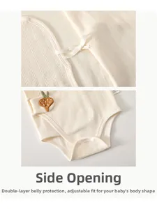 Detail of baby organic cotton romper with carrot embroidery and side-tie closure design