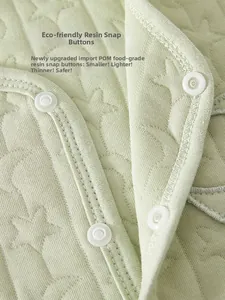 Macro detail of food-grade resin snap buttons on quilted baby vest fabric