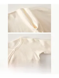 Close-up of seamless stitching on soft rib-knit cotton baby bodysuit in cream white