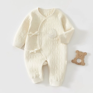 Gros plan détaillé de la barboteuse en coton matelassé avec motifs étoiles et lunes