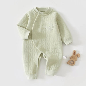 Detailed quilted texture of baby romper with star patterns and crescent moon embroidery