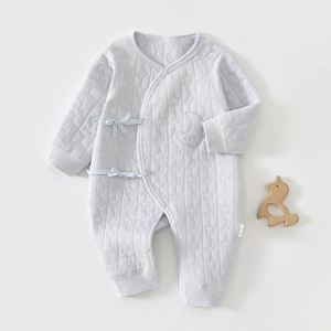 Détail de barboteuse matelassée bleu clair pour bébé avec motifs lune étoiles et broderie