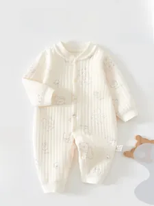 Détail de grenouillère bébé beige côtelée avec motifs ours et boutons-pression pratiques