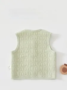 Detail of the back of a light green quilted baby vest with star and moon patterns