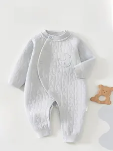 Détail d'une grenouillère matelassée grise pour bébé avec texture étoiles et lune gaufrée