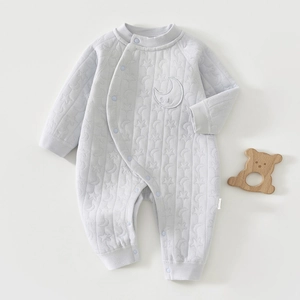 Detail of baby quilted romper featuring star pattern texture and moon embroidery