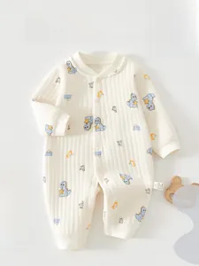 Detail of soft ribbed long-sleeve baby romper with dinosaur prints and button closure