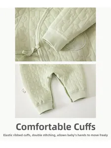 Detail of light green baby quilted romper showing side tie closure and star moon texture