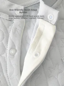Détail des boutons-pression en résine éco et broderie d'étoiles sur barboteuse grise