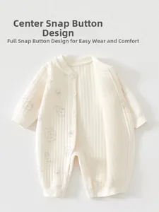Détail de la barboteuse en coton avec boutons-pression, texture côtelée et ours