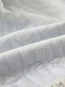 Gros plan du tissu matelassé doux pour barboteuse bébé avec motif d'étoiles et coutures