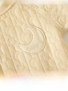 Close-up of baby romper featuring star and moon jacquard texture and moon patch embroidery
