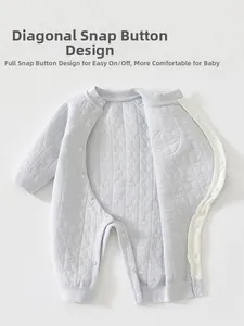 Détail d'une barboteuse matelassée pour bébé avec motifs lune, étoiles et pressions