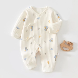 Detail of soft ribbed cotton baby romper featuring blue dinosaur and star prints