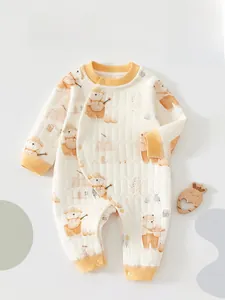 Détails d'une barboteuse matelassée pour bébé avec motifs ours et bordures jaunes