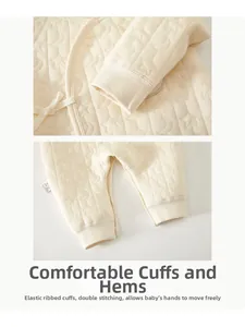 Detailed macro view of the star-moon quilted fabric and ribbed cuffs on baby romper