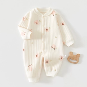 Detail of baby floral cotton jumpsuit with ribbed texture and snap button closure