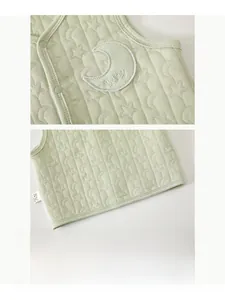 Detailed view of baby vest featuring quilted star moon pattern and press stud buttons