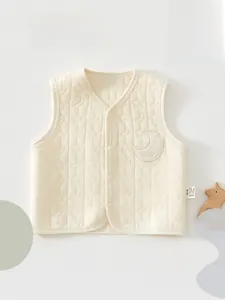 Detail of baby quilted vest featuring moon star patterns and soft cotton fabric texture