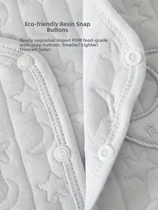 Detail of infant quilted vest showing grey star moon fabric and POM resin snap buttons